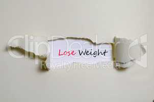 The word lose weight appearing behind torn paper