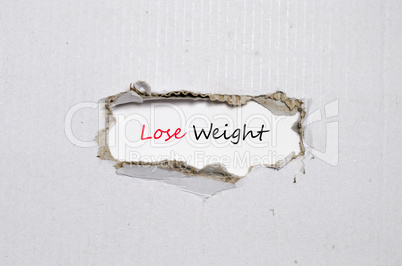 The word lose weight appearing behind torn paper