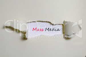 The word mass media appearing behind torn paper