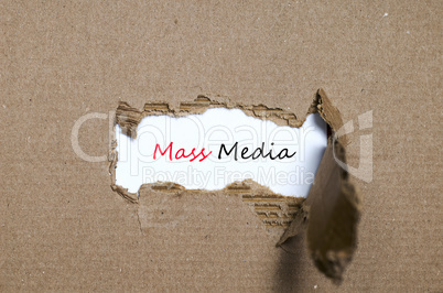 The word mass media appearing behind torn paper