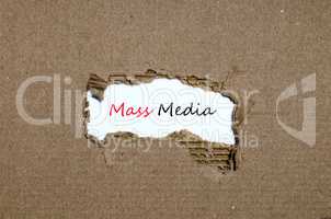 The word mass media appearing behind torn paper