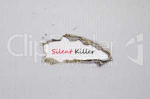 The word silent killer appearing behind torn paper