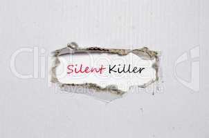 The word silent killer appearing behind torn paper