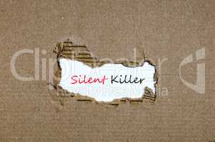 The word silent killer appearing behind torn paper