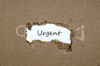 The word urgent appearing behind torn paper