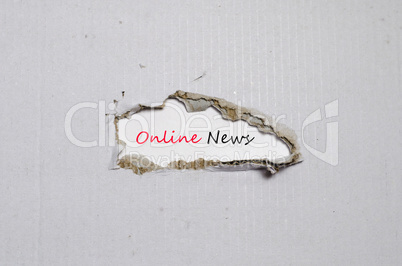 The word online news appearing behind torn paper