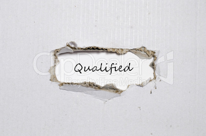 The word qualified appearing behind torn paper