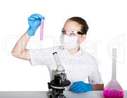 Attentive schoolgirl conducting a chemistry experiment at elementary science class. studying the bacteria through a microscope