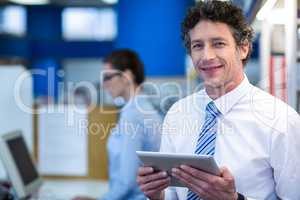 Smiling pharmacist holding digital tablet in pharmacy