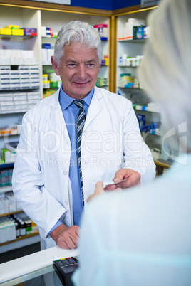 Pharmacist giving bill to customer