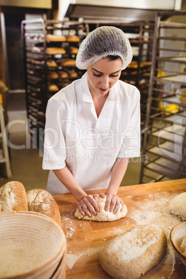 Female baker kneading a dough