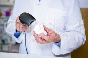 Pharmacist using barcode scanner on medicine container