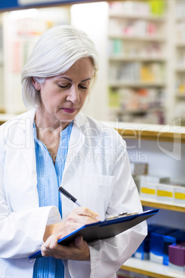 Pharmacist writing on clipboard Pharmacist writing on clipboard
