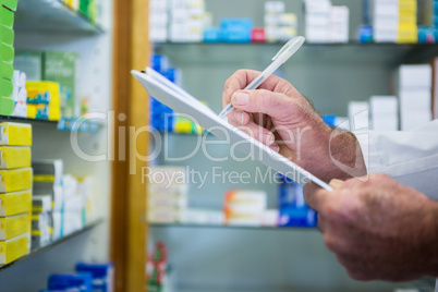 Pharmacist writing on clipboard