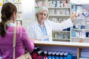 Pharmacist showing the bottle of drug to customer