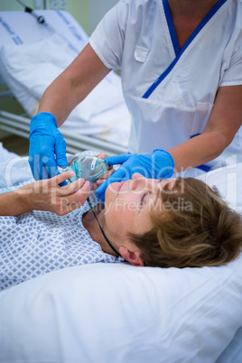 Nurse placing an oxygen mask on the face of a patient