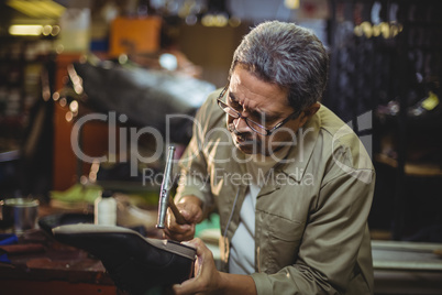 Shoemaker hammering on a shoe