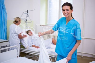 Nurse preparing a bed for a patient