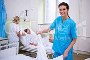 Nurse preparing a bed for a patient