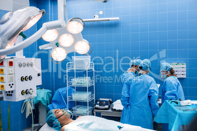 Surgeons interacting with each other while patient lying on oper