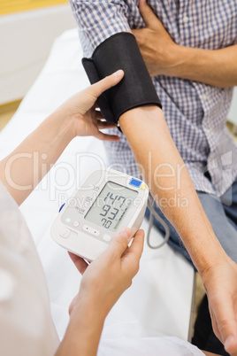 Female doctor checking blood pressure of patient