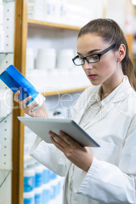 Pharmacist using digital tablet while checking medicine Pharmacist using digital tablet while checking medicine