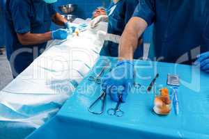 Surgeon taking a scissors from tray