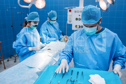 Surgeon taking a scissors from tray