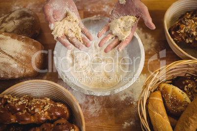 Hands of baker mixing flour by hand