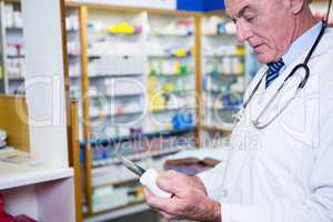 Pharmacist holding digital tablet while checking medicine