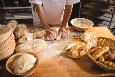 Mid-section of baker kneading a dough