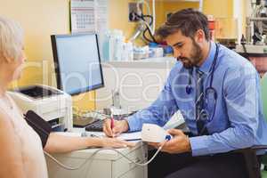 Doctor checking blood pressure of patient
