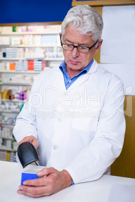 Pharmacist using barcode scanner on medicine box
