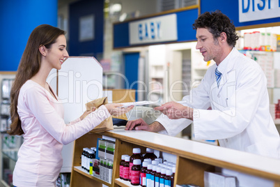 Pharmacist giving medicine package to customer