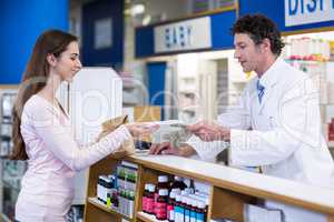 Pharmacist giving medicine package to customer