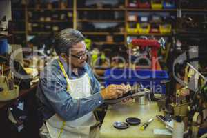 Shoemaker polishing a shoe