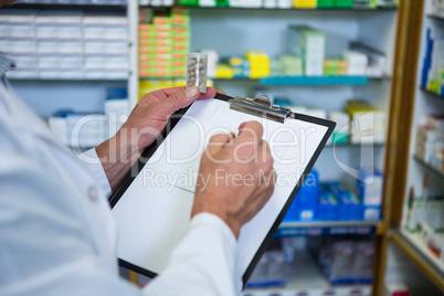 Pharmacist writing on clipboard