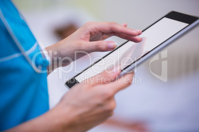 Nurse using digital tablet in hospital ward
