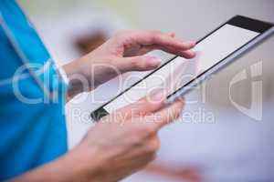 Nurse using digital tablet in hospital ward