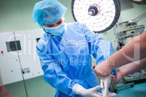 Nurse helping a surgeon in wearing surgical gloves