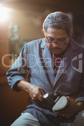 Shoemaker making a shoe with hammer