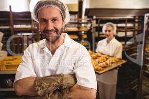 Portrait of male baker standing with arms crossed