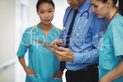 Doctor and nurses discussing over digital tablet