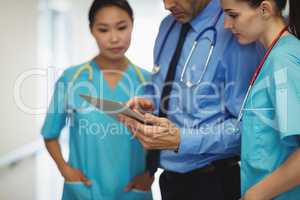 Doctor and nurses discussing over digital tablet