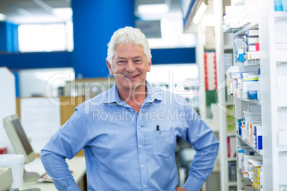 Pharmacist standing with hand on hip in pharmacy