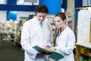 Pharmacists discussing over medical report