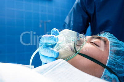 Surgeon placing an oxygen mask on the face of a patient