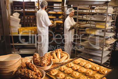 Michetta and sweet food on a table while male and female baker w