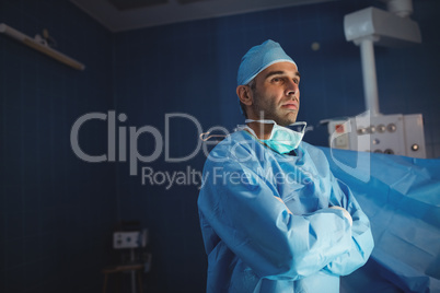 Surgeon standing with arms crossed in operation room