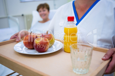 Mid section of nurse holding a breakfast